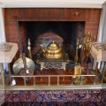 D03. Brass fireplace fender with cushioned seats and other fireplace accessories. 